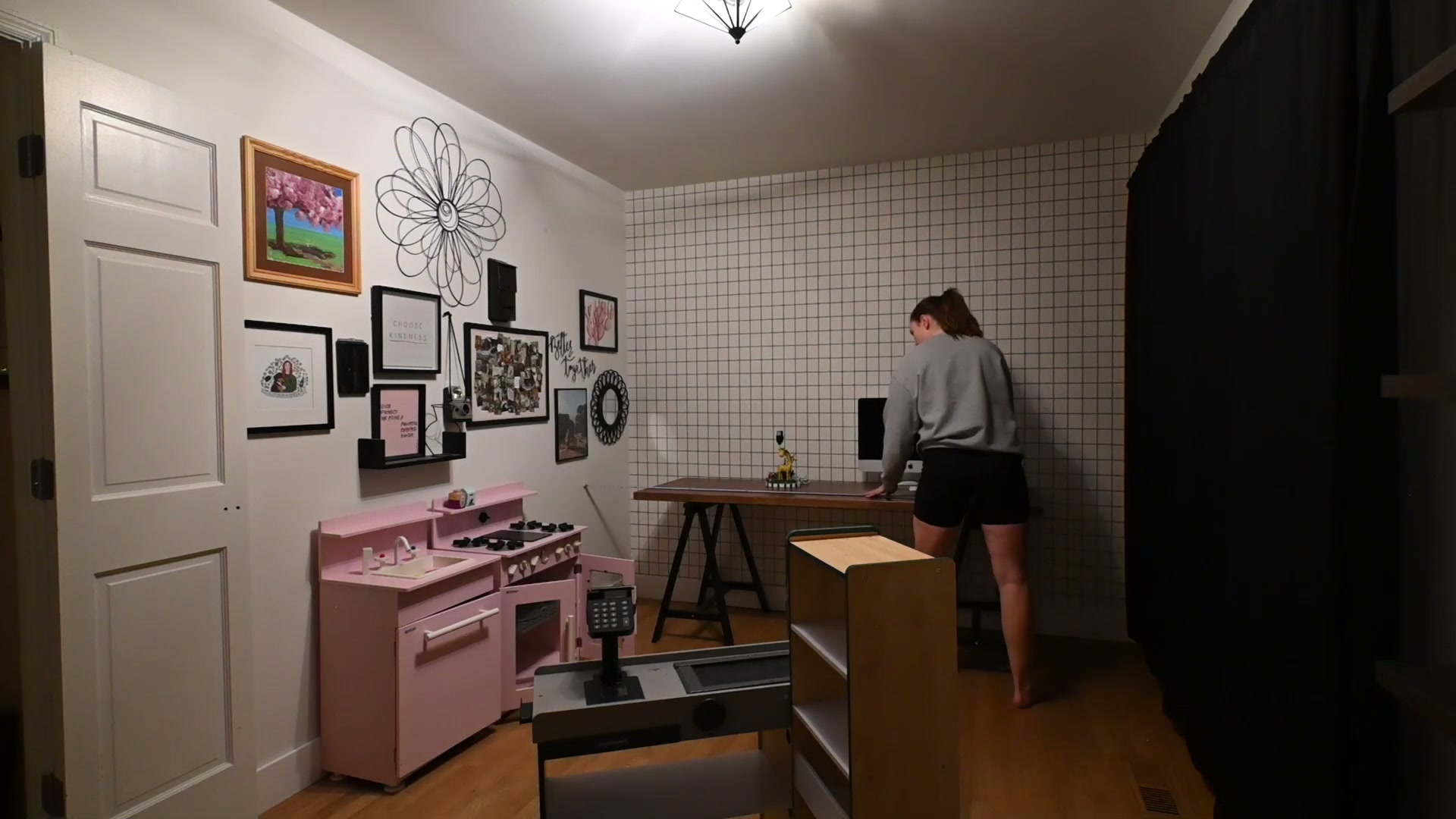 The dual-zone layout taking shape — play kitchen on one wall, work desk on the other.